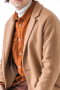This men's custom made tan colored coat is tailor made in a fine wool and tweed, featuring a single breasted button closure, slanted welt pockets, and a center vent. 