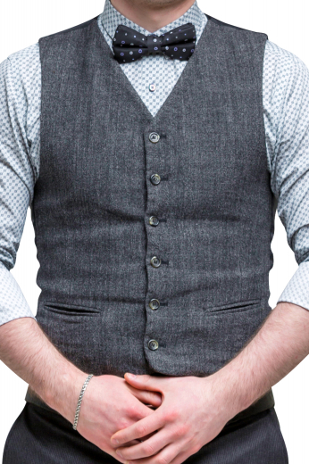 A custom bespoke men's hand tailored dark grey vest. This stunning men's vest is tailor made in a wool blend featuring a single breasted closure and v neck, with piped lower pockets. 